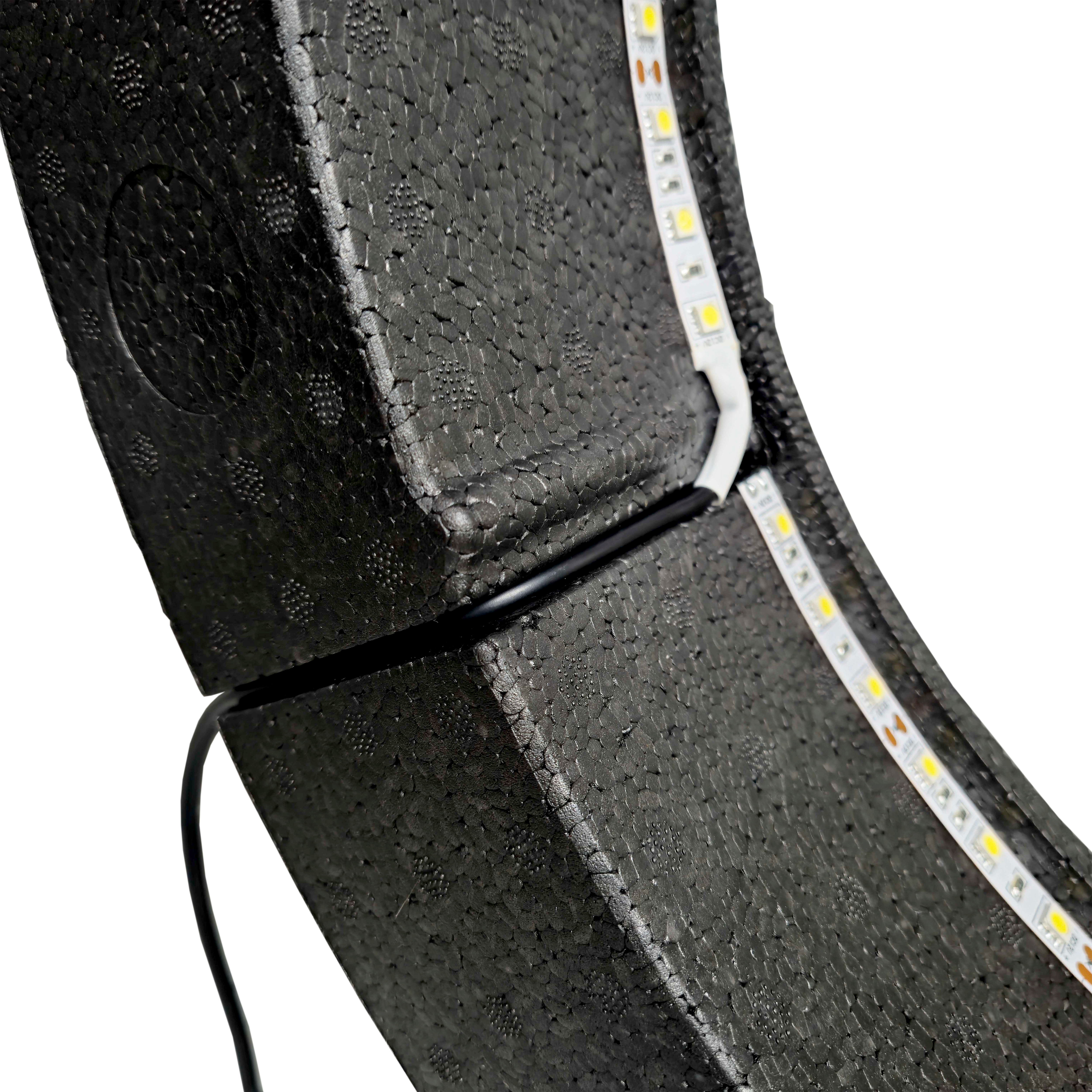 System oświetlenia przestrzennego Bulls NL Lumo Light Das Bild zeigt das „Bulls NL Lumo Light Surround Beleuchtungssystem“ mit LED-Leuchtstreifen auf einer schwarzen, strukturierten Oberfläche. Ein Kabel ist ebenfalls an das Beleuchtungssystem angeschlossen.