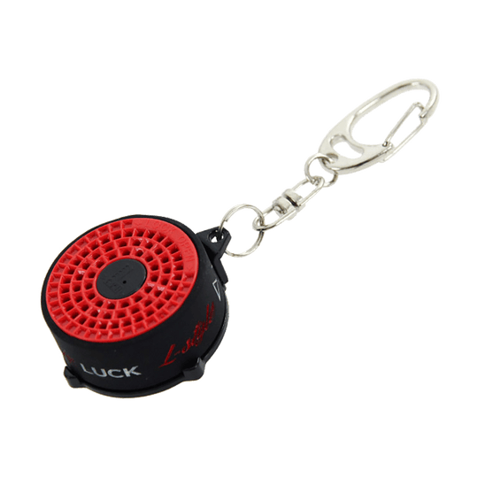 LSF18_L-Style_Bull_Spitzen-und-Shaftrestentferner_1 Das Bild zeigt den "L-Style BULL Spitzen- und Shaftrestentferner" mit einem Schlüsselanhänger. Das Produkt ist rund, überwiegend schwarz mit einer roten Oberseite.