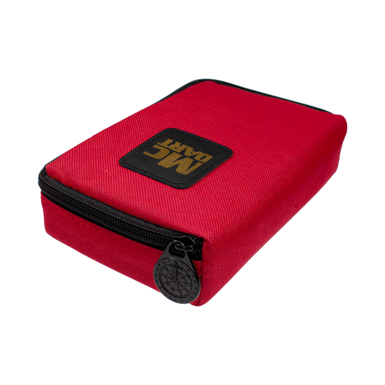 Auf dem Bild ist eine kleine, rote Tasche mit Reißverschluss zu sehen. Auf der Tasche befindet sich ein schwarzes Patch mit der goldenen Aufschrift "MC DART".