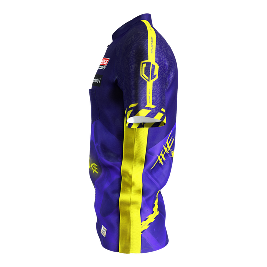 Koszulka do darta Target Coolplay Luke Littler 2025 Das Bild zeigt ein Dartshirt in lila und gelb mit auffälligem Design. Auf dem Ärmel steht "LUKE LITTLER" und es sind verschiedene grafische Elemente abgebildet.