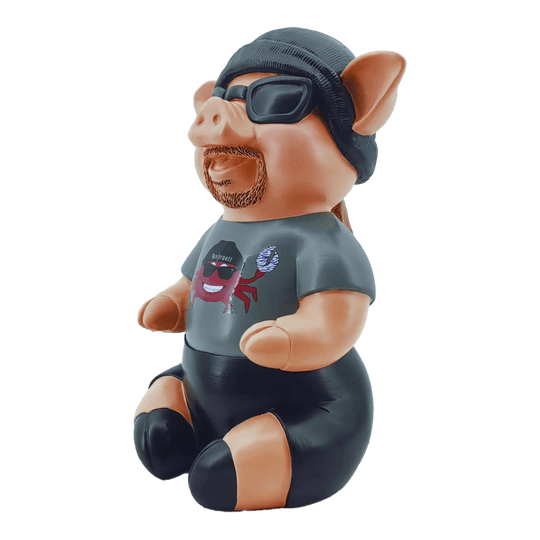 Markus Krebs Fraza Świnka Das Bild zeigt eine Schweinfigur namens "Markus Krebs Phrasenschwein". Sie trägt eine Sonnenbrille, eine Mütze und ein T-Shirt mit Aufdruck.