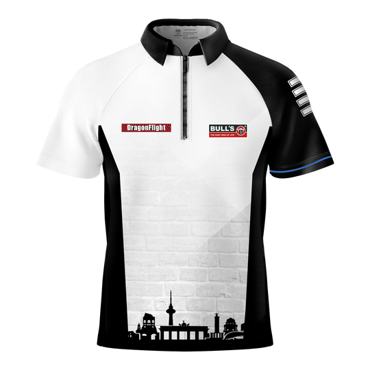 Koszulka Bulls Martin Schindler The Wall z lotkami Das Bild zeigt das Bulls Martin Schindler The Wall Dartshirt mit einem schwarz-weißen Design und kurzen Ärmeln. Auf der Vorderseite befinden sich Logos und eine stilisierte Stadtsilhouette am unteren Rand.
