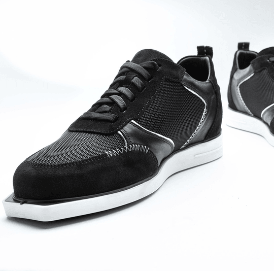 Die Abbildung zeigt die Triple20 Dartschuhe aus Textil und Leder in Schwarz-Weiß. Die Schuhe haben ein sportliches Design mit weißer Sohle und auffälligen Nähten.
