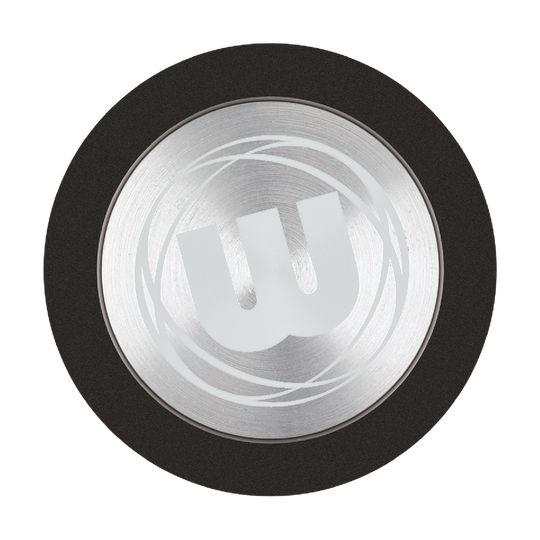 Das Bild zeigt den Winmau Premium Point Protector für Steeldarts. Es handelt sich um einen runden, silbernen Schutz mit einem großen "W"-Logo in der Mitte.