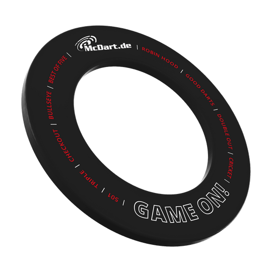 Gra McDart na tarczy do darta Das Bild zeigt einen schwarzen Dartboard-Surround-Ring mit der Aufschrift "McDart.de" und "GAME ON!". Um den Ring sind weitere Begriffe rund um das Dartspiel in Rot und Weiß geschrieben.