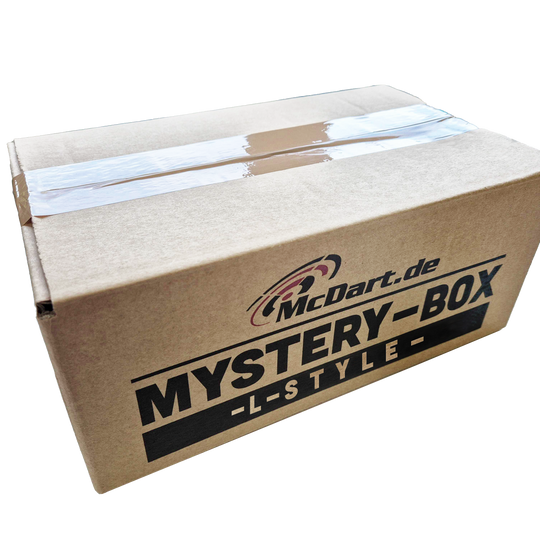 McDart Mystery Box - w stylu L Auf dem Bild ist ein brauner Karton mit der Aufschrift „McDart.de MYSTERY-BOX -L-STYLE-“ zu sehen. Die Box ist mit Klebeband verschlossen.