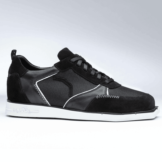 Der Schuh "Triple20 Dartschuhe Textil Leder - Schwarz Weiß" ist ein sportlicher Sneaker in Schwarz mit weißen Akzenten. Er besteht aus einer Kombination aus Textil und Leder und hat eine weiße Sohle.