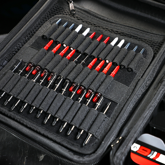 Winmau Armor G4 Dartwallet Das Bild zeigt ein geöffnetes schwarzes Dartwallet mit vielen ordentlich einsortierten Dartspitzen. Die Dartspitzen sind in elastischen Schlaufen gehalten und teilweise rot, weiß oder schwarz gefärbt.