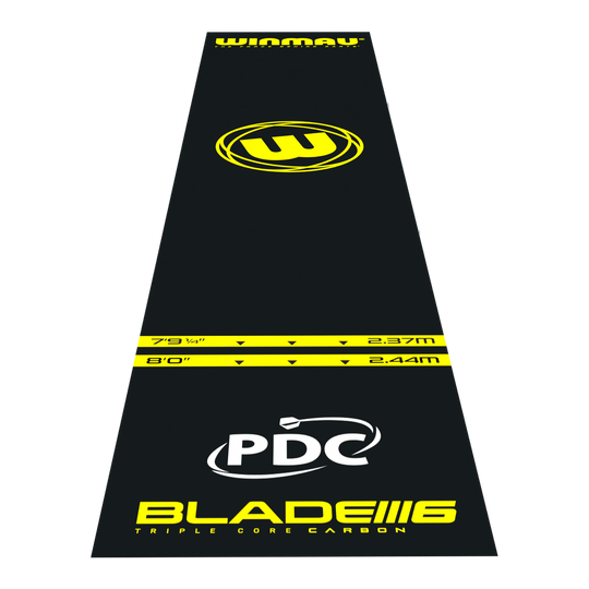 Mata do rzutek Winmau Pro-Zone Essential PVC Das Bild zeigt die Winmau Pro-Zone Essential PVC Dartmatte in schwarzer Farbe mit gelben Markierungen. Auf der Matte sind verschiedene Entfernungsmarkierungen, das Winmau-Logo sowie die Aufschrift "BLADE 6" und "PDC" zu sehen.